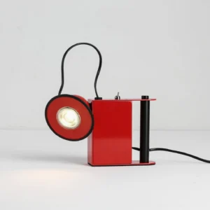 Red Minibox compact industrial table lamp, side view with illuminated spotlight and power cord, minimalist backdrop