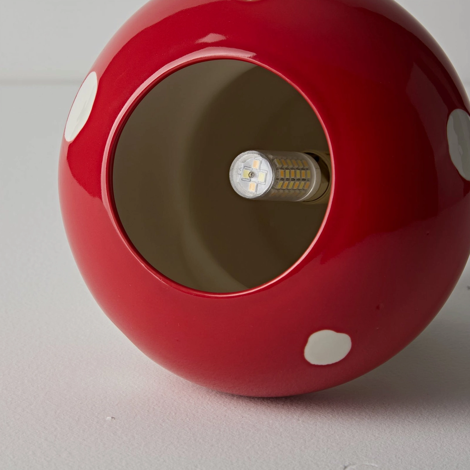 Red mushroom ceiling light paired with Scandinavian minimalist furniture and décor