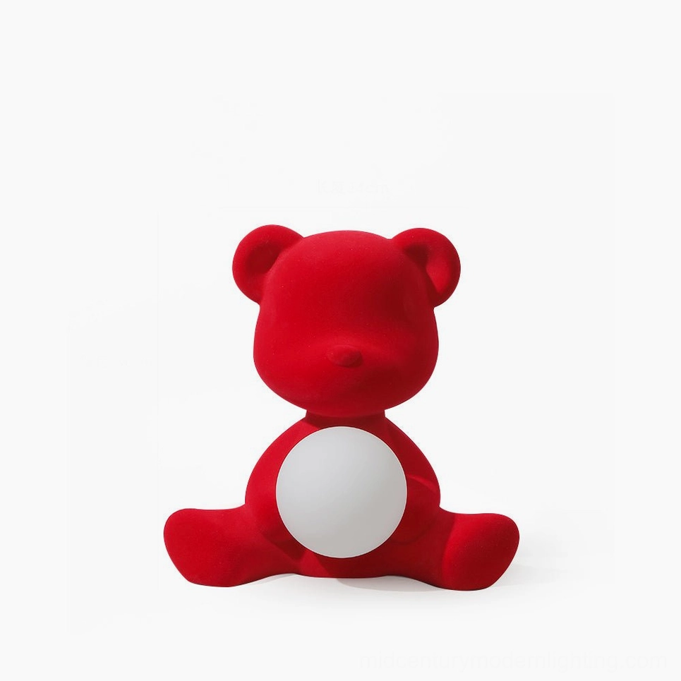 Red flocked teddy bear table lamp with glowing spherical light, frontal view on white background