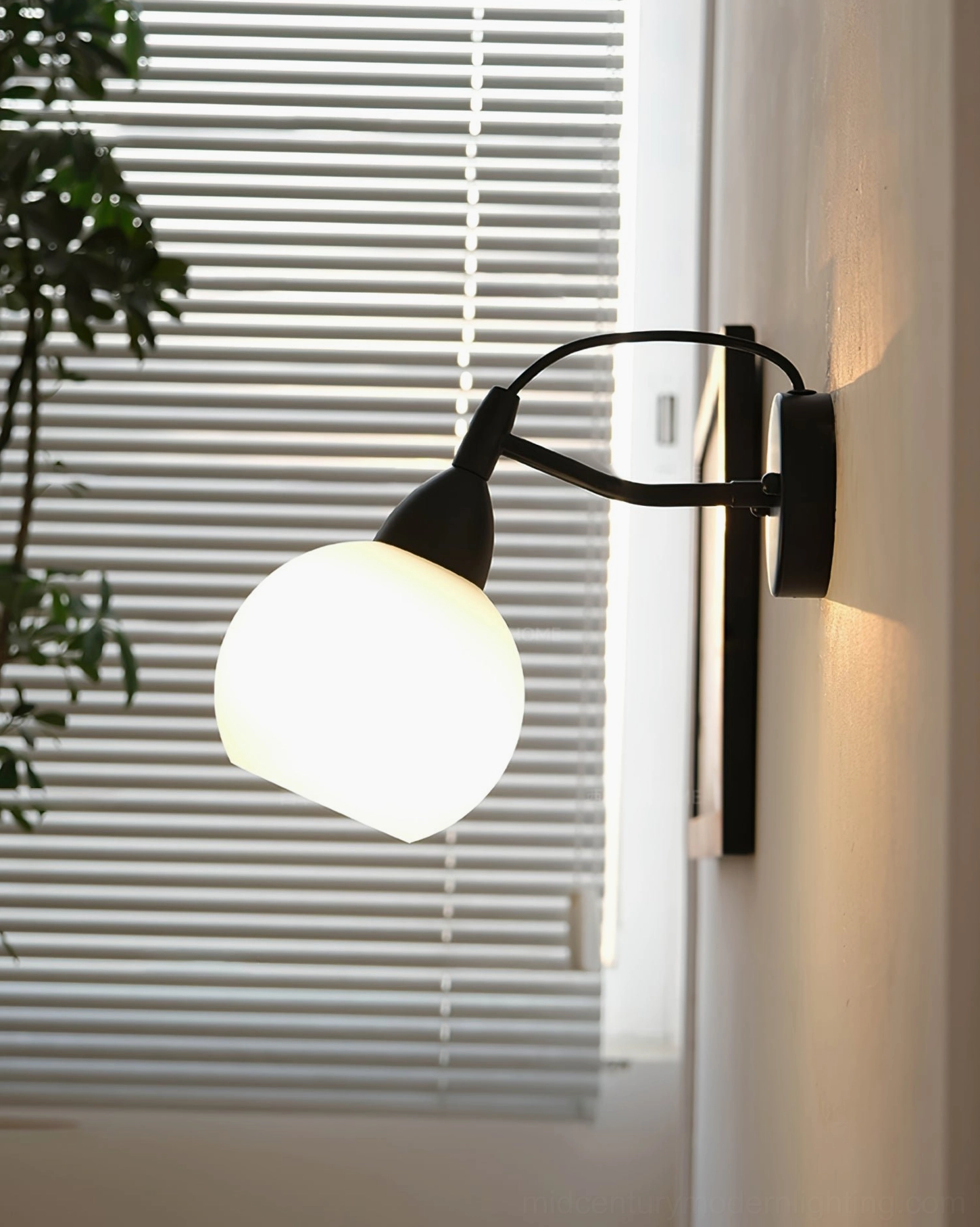 Reese frosted glass wall lamp warm ambient lighting near window area with blinds and potted plants