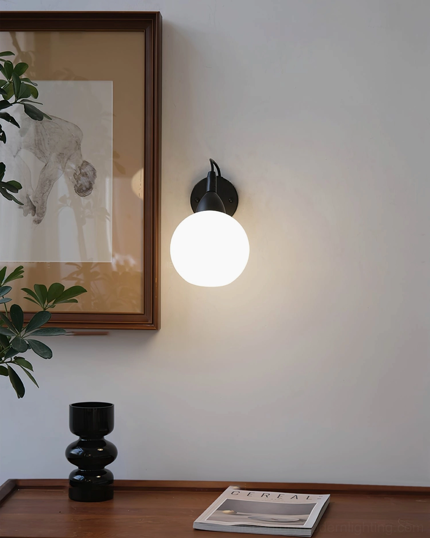 Reese glass ball wall lamp eye-level side view in minimalist residential entryway with wooden console