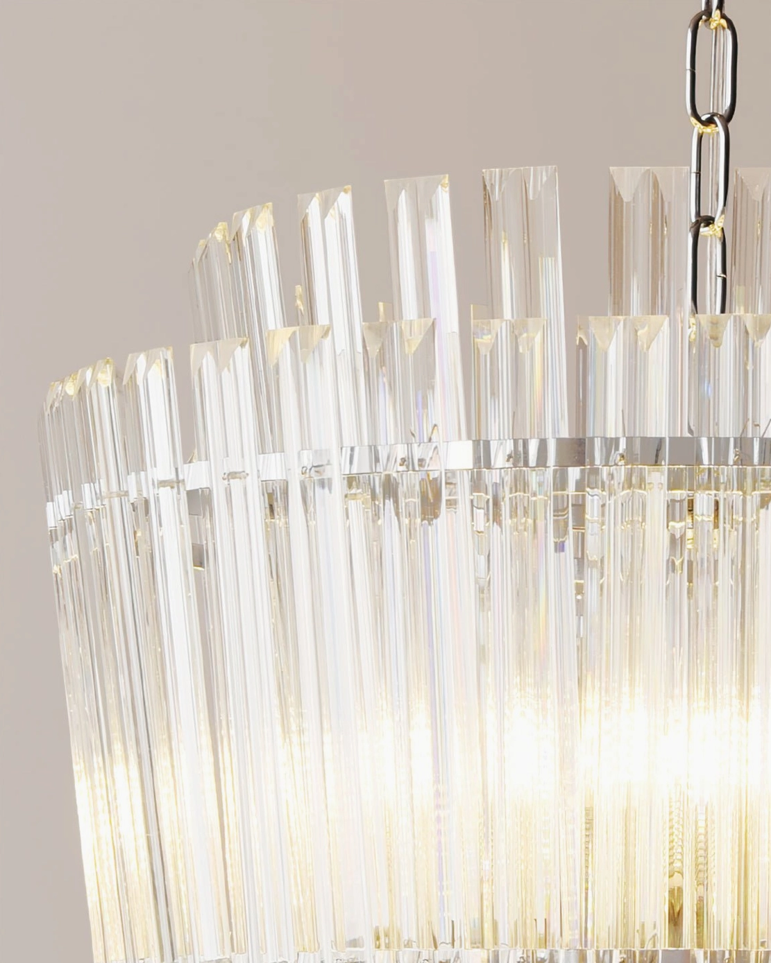 Extreme close-up of Regina chandelier glass rods revealing detailed striated texture and polished chrome chain suspension