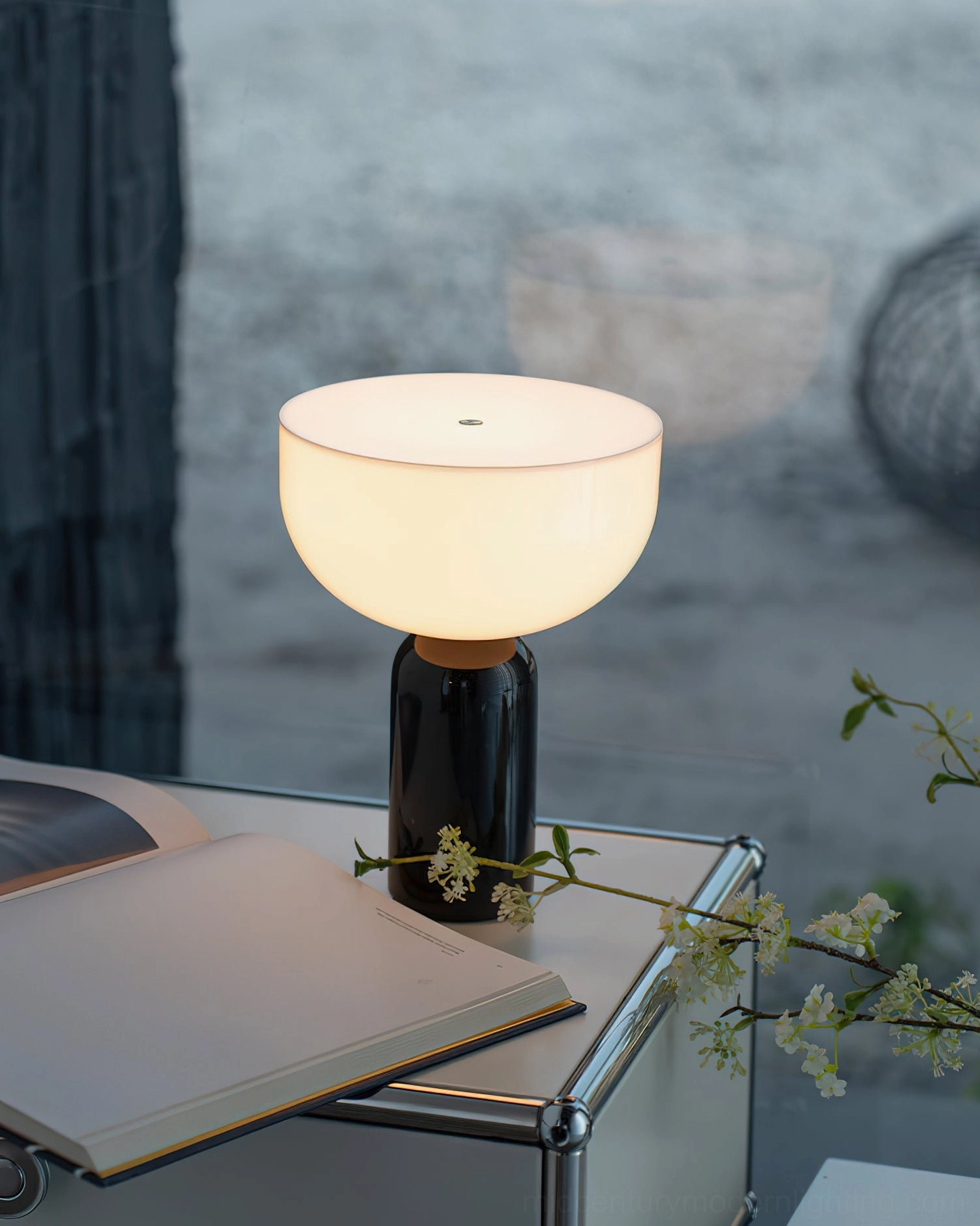 Black marble base Renard lamp with warm frosted glass diffuser on desk with book and flower decor