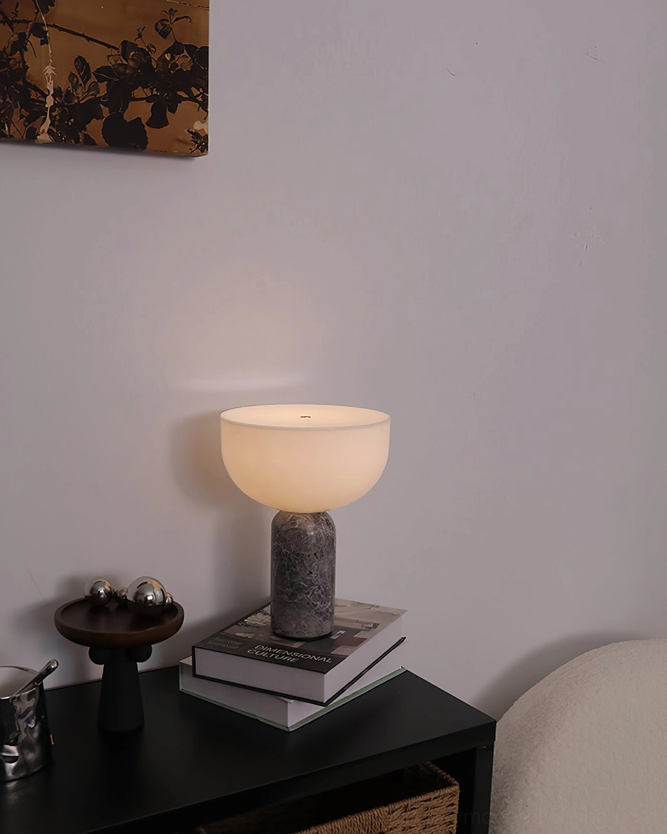 Renard marble table lamp with gray base on stacked books in minimalist home decor three-quarter view