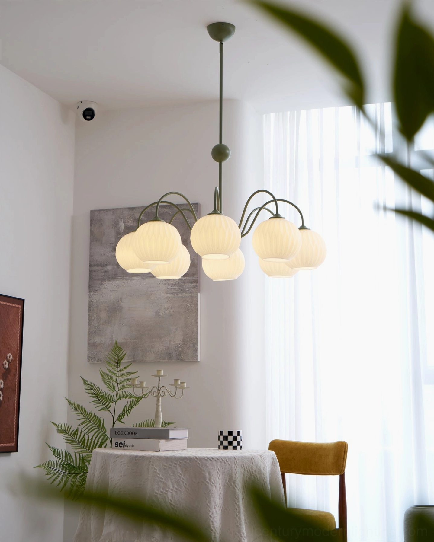 Renee white globe chandelier hung in bright modern bedroom with natural light and minimalist aesthetic