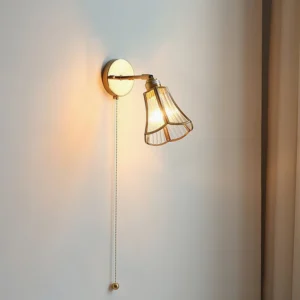 Compact Rennes wall lamp brass and glass side angle with warm glow