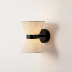 Close-up detail of Renwick wall sconce showing textured linen fabric weave and black metal accent band