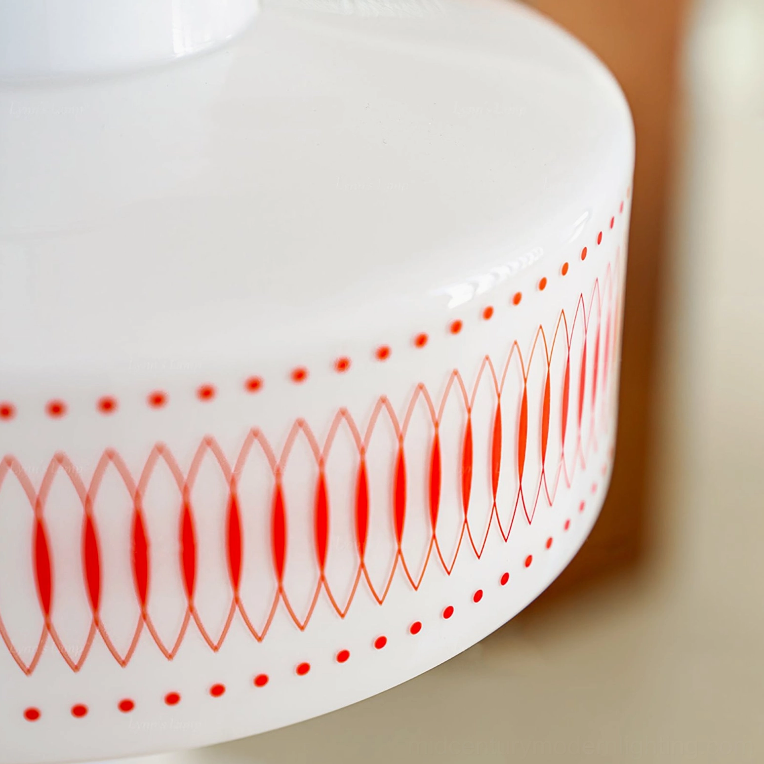Hand-printed geometric texture showing burnt-orange oval and dot pattern on white glass shade of Retro Circle lighting
