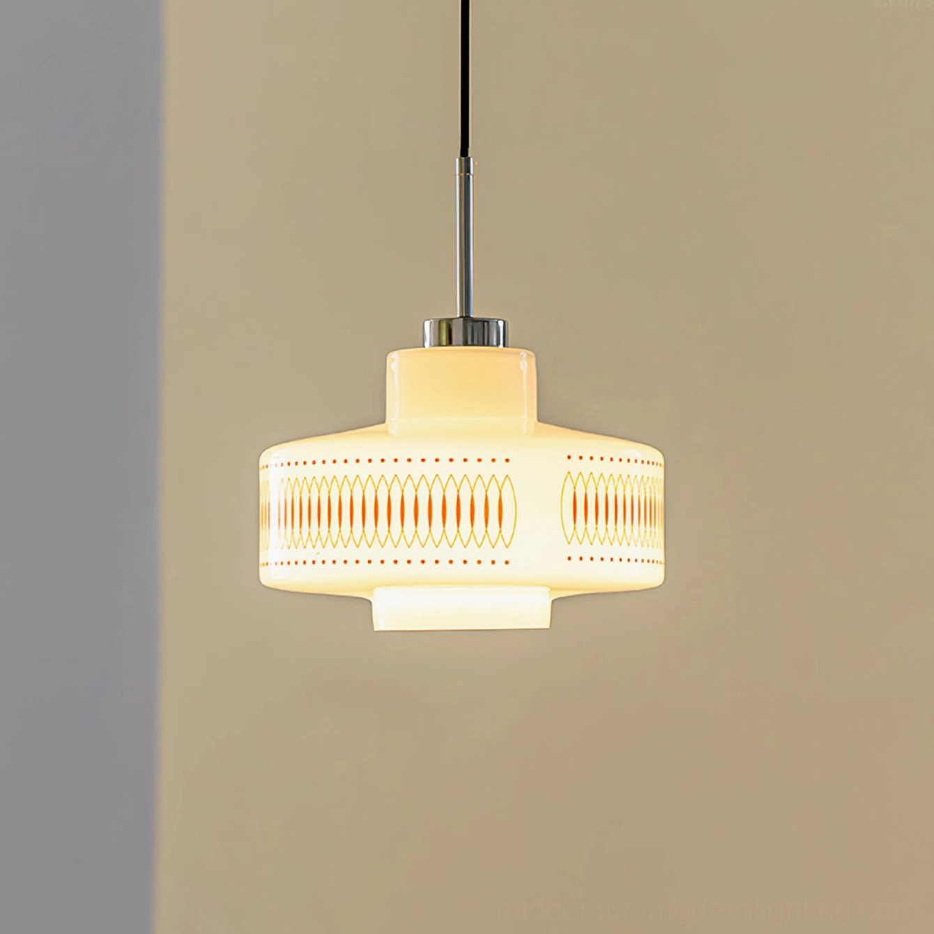 Full front view of activated Retro Circle pendant with soft yellow light radiating through hand-printed pattern on white glass