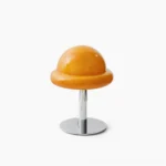 Orange mushroom table lamp with glossy glass dome and polished chrome metal base on white studio background