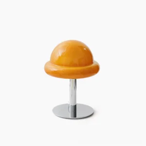Orange mushroom table lamp with glossy glass dome and polished chrome metal base on white studio background