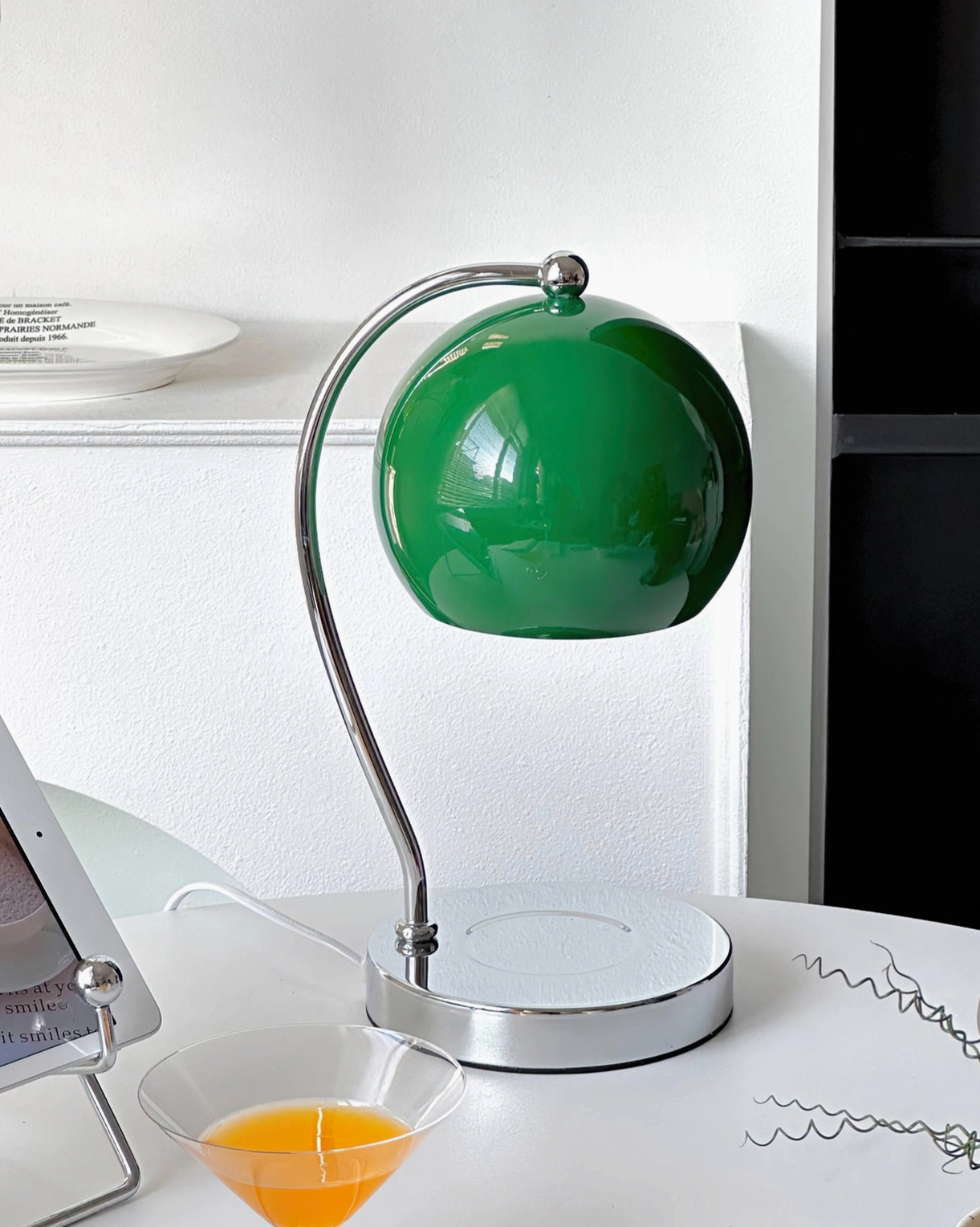 Green shade sphere lamp with silver round base on home desk corner minimalist workspace