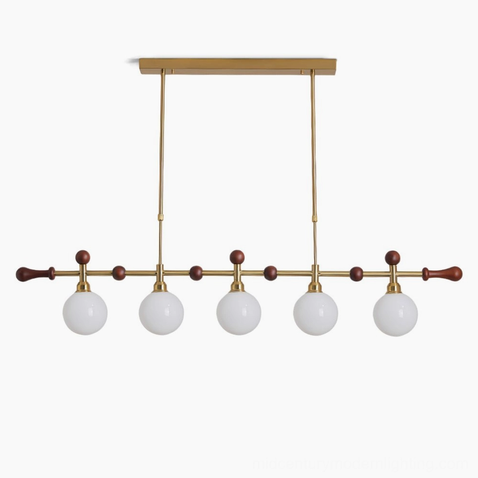 Reya linear chandelier with 5 glass globe shades in brass gold and walnut wood, front studio view showing mid-century modern design details