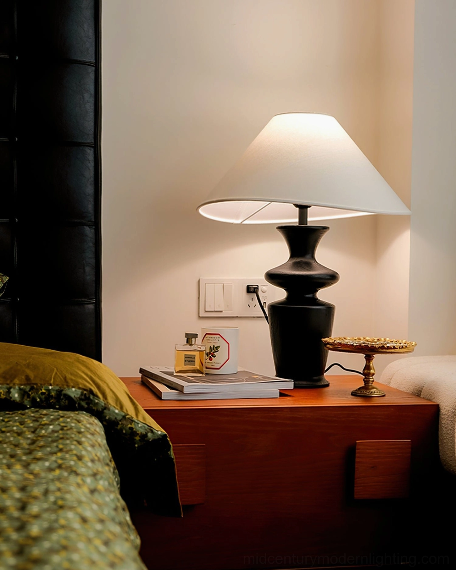 Rhodes table lamp providing bedside lighting with dark leather headboard and nightstand decor