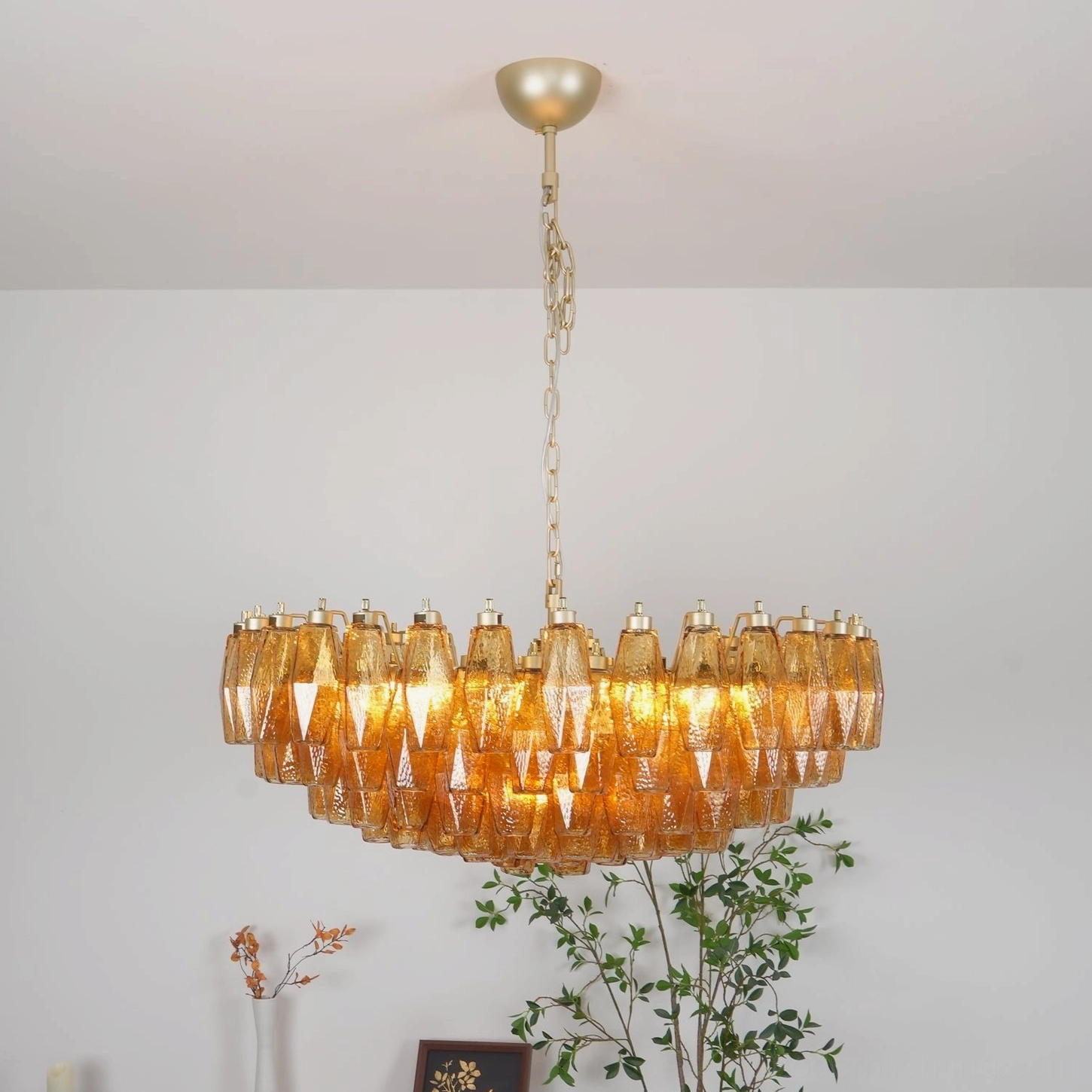 Amber glass rhombus chandelier installed as sculptural lighting centerpiece in contemporary interior