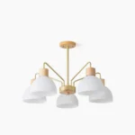5-head ribbed glass chandelier with gold metal frame and pleated white glass shades, overhead studio view