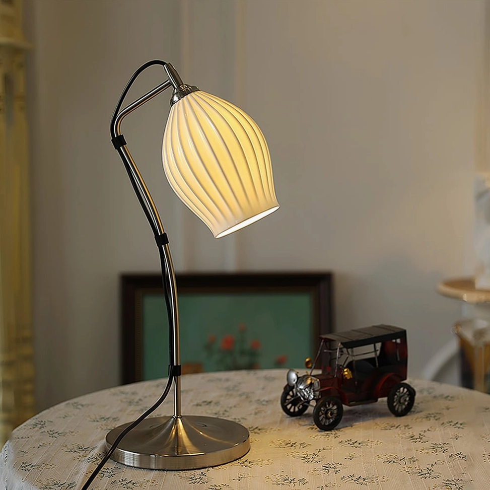 Black metal arm ribbed table lamp on vintage round dining table with toy car collectible decor