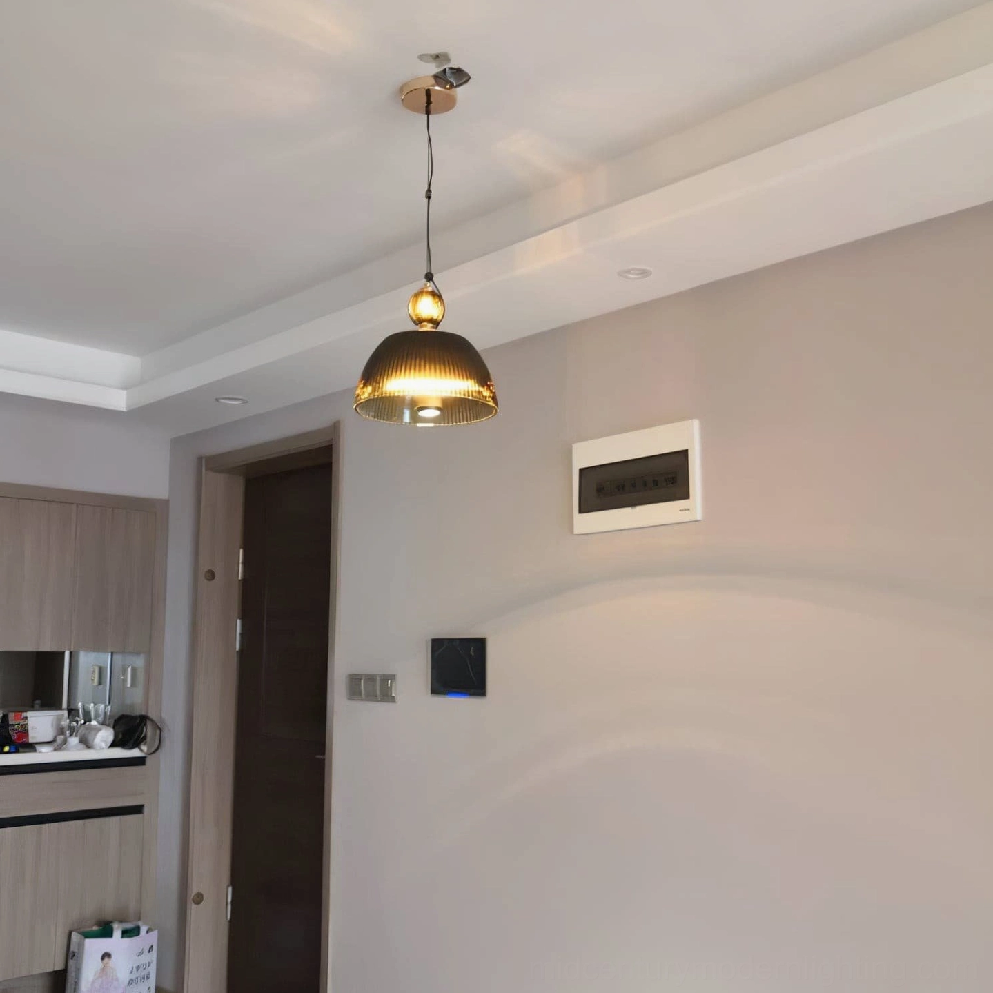 Ribbed glass pendant light fixture detail showing metal mounting bracket and suspension hardware assembly