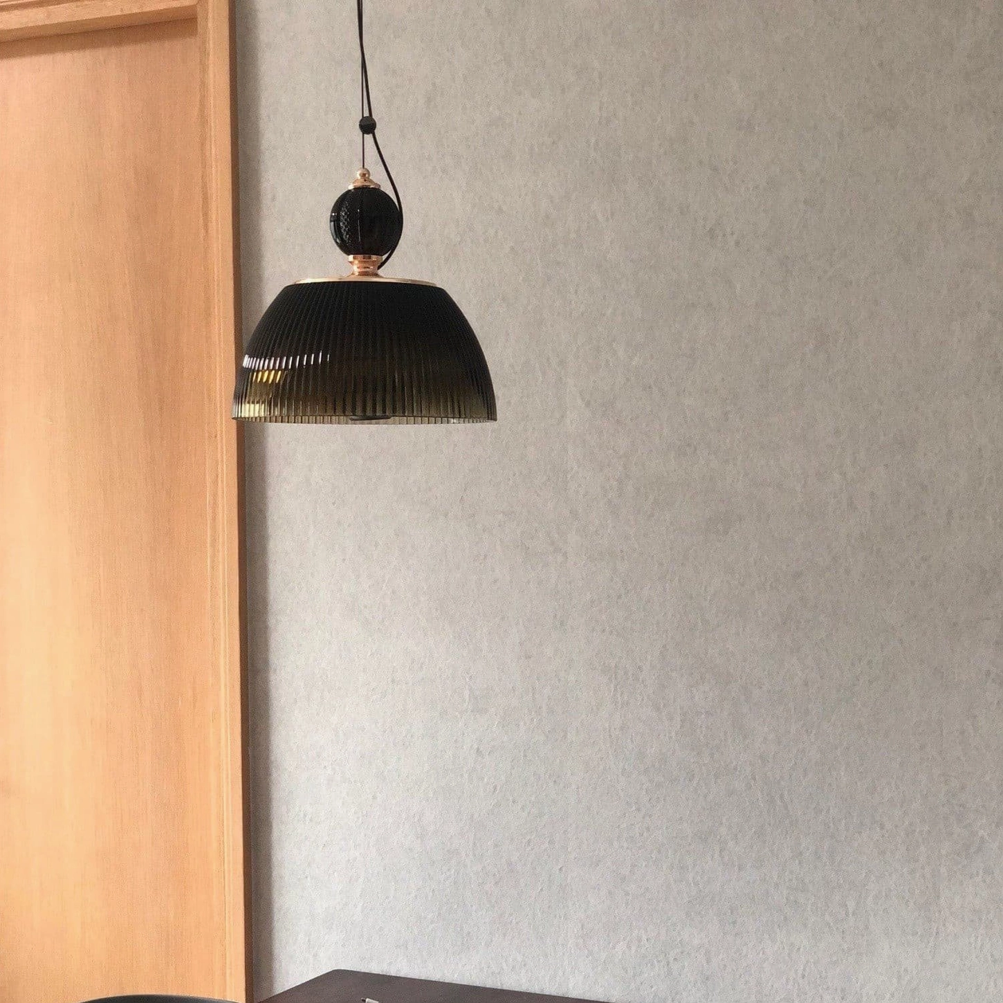 Ribbed glass pendant fixture detail showing brass or metal top mounting hardware and quality construction