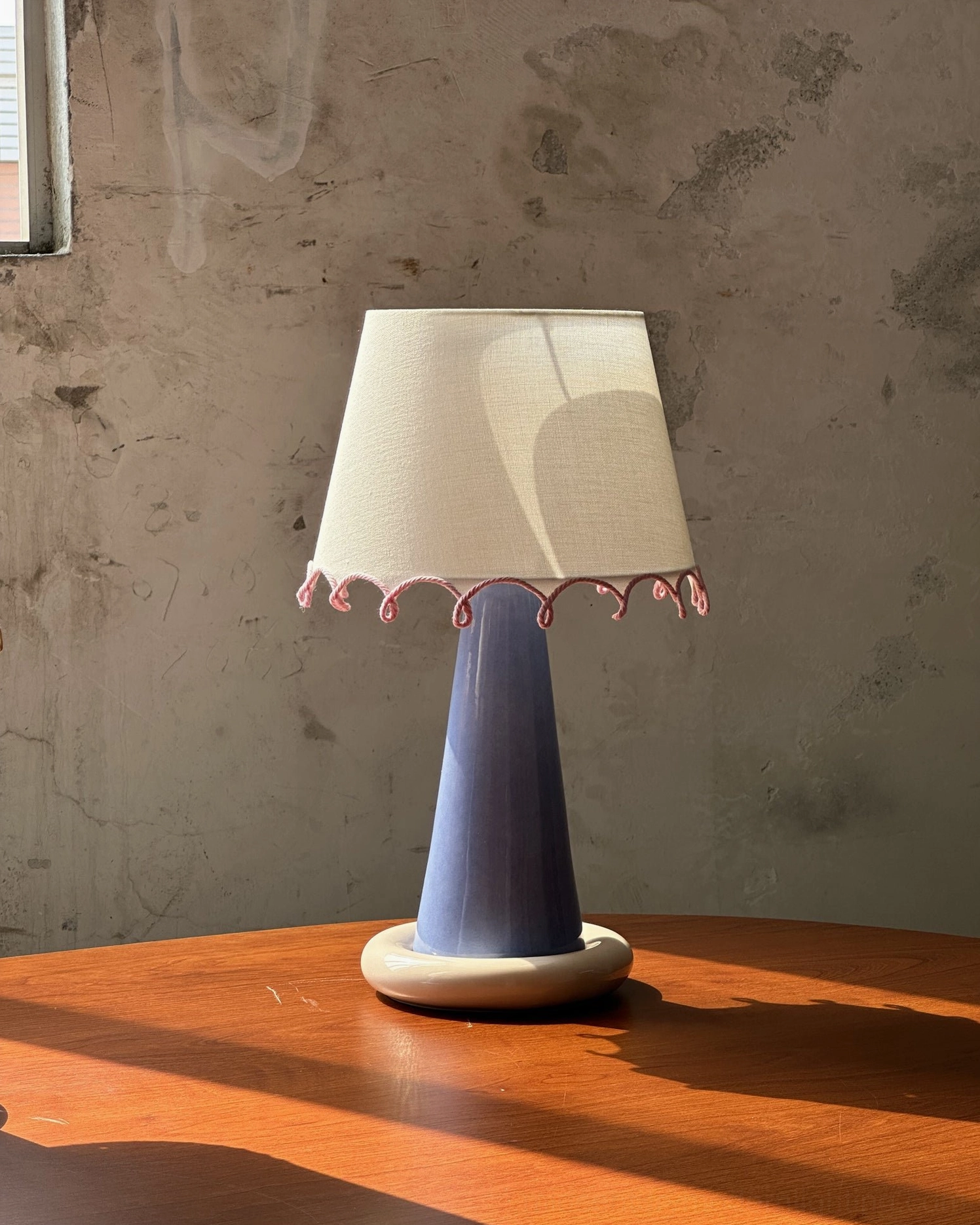 Ribbon table lamp showing both color finish options and sculptural ceramic base design elements