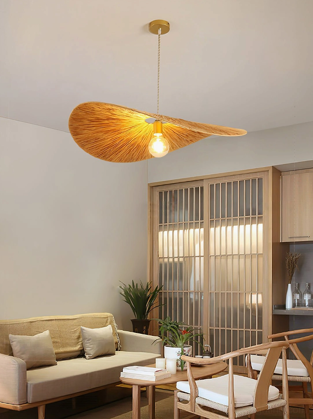 Ridotti hand-woven rattan pendant lamp in Japanese-style small lounge area showing warm golden light through natural material