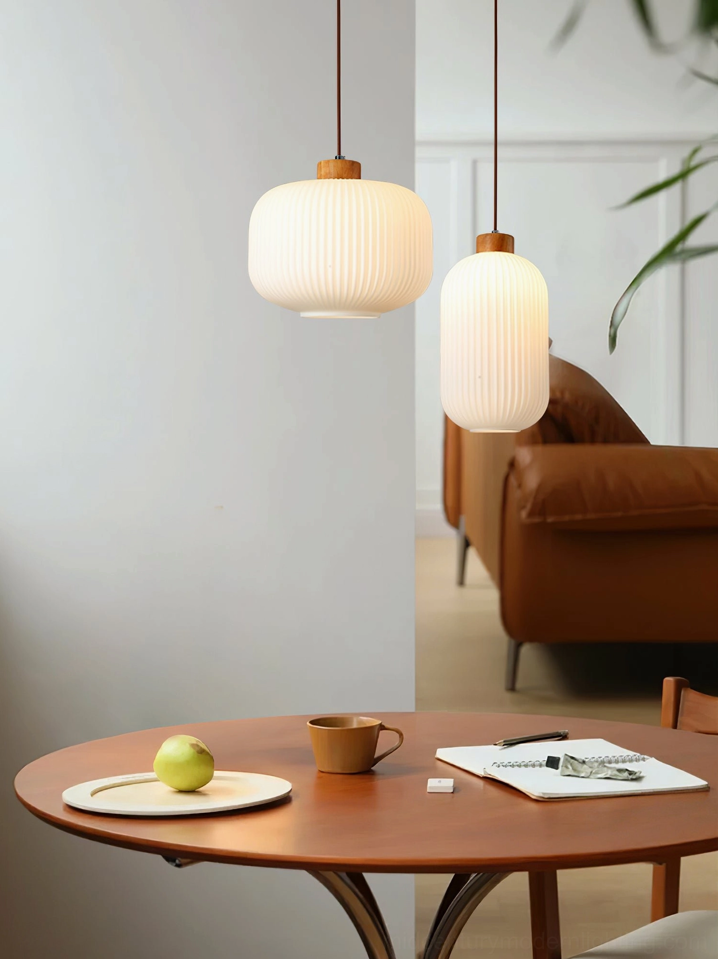 Two Rime pendant lamps illuminated over dining area with warm wooden finishes and minimalist decor