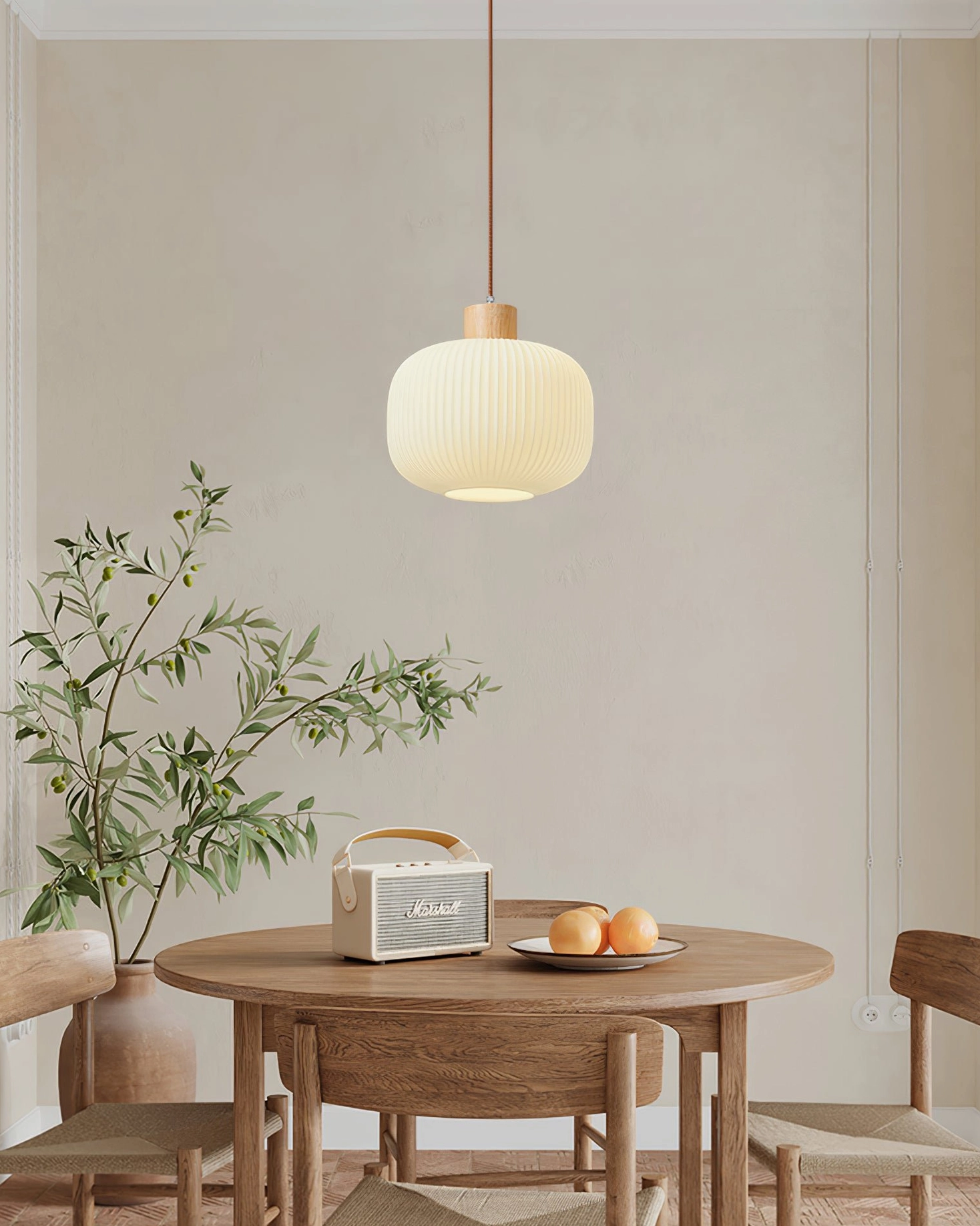 Single round Rime pendant lamp above Japanese-inspired wooden dining table in warm minimalist interior