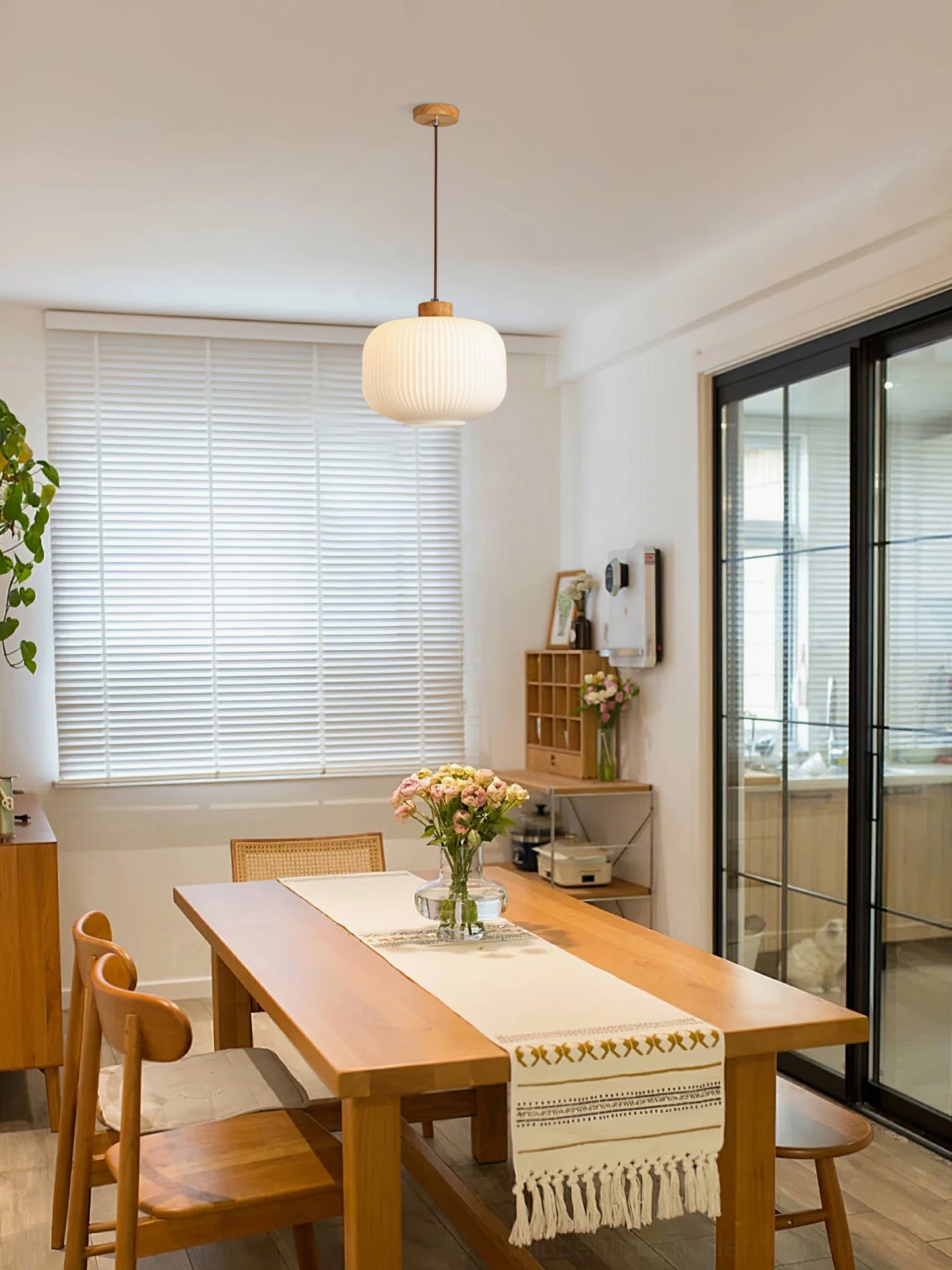 Rime pendant lamp suspended in bright modern dining and kitchen space with open shelving