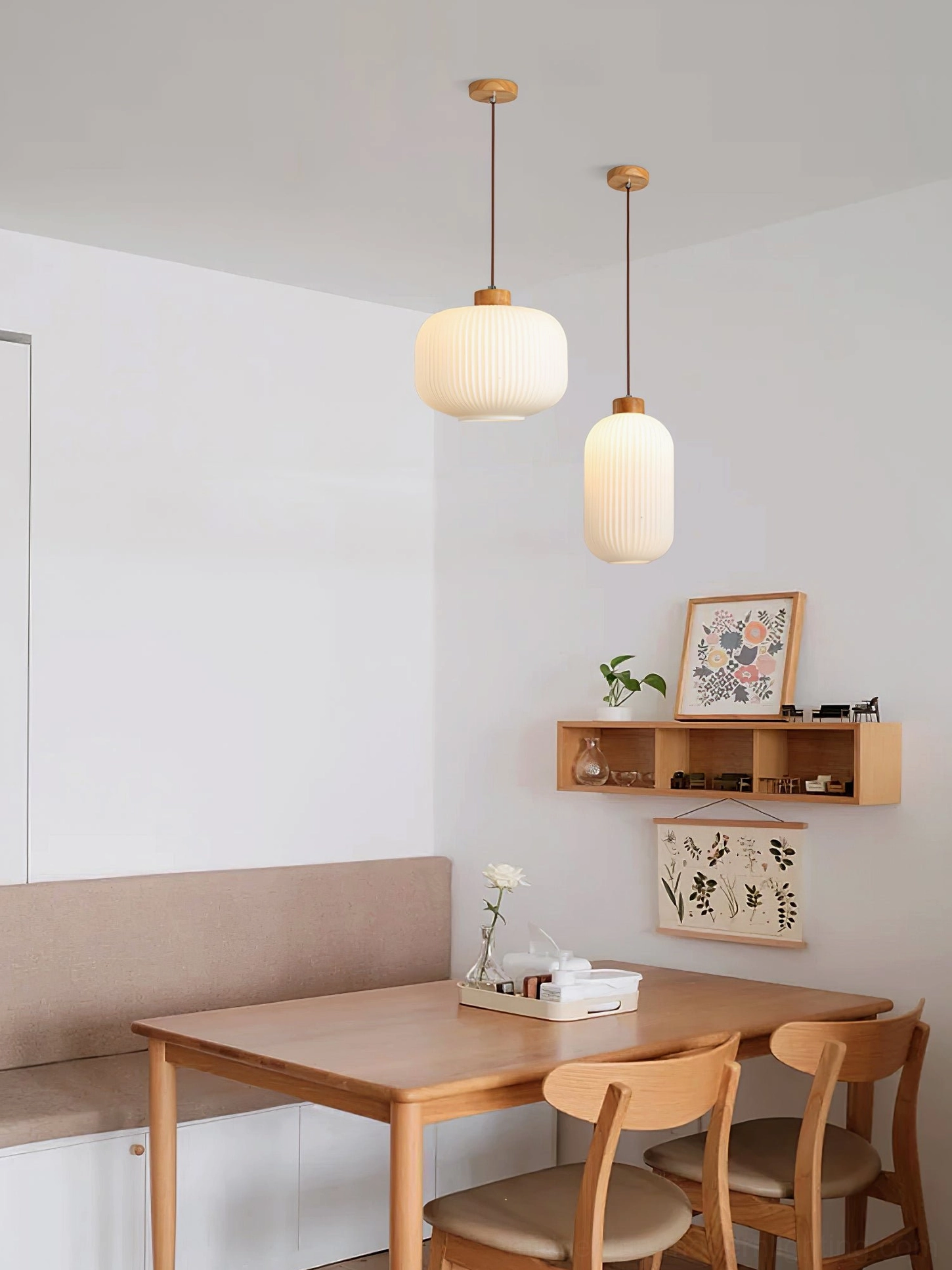 Pair of Rime pendant lamps over dining table with wall-mounted shelving and warm neutral palette