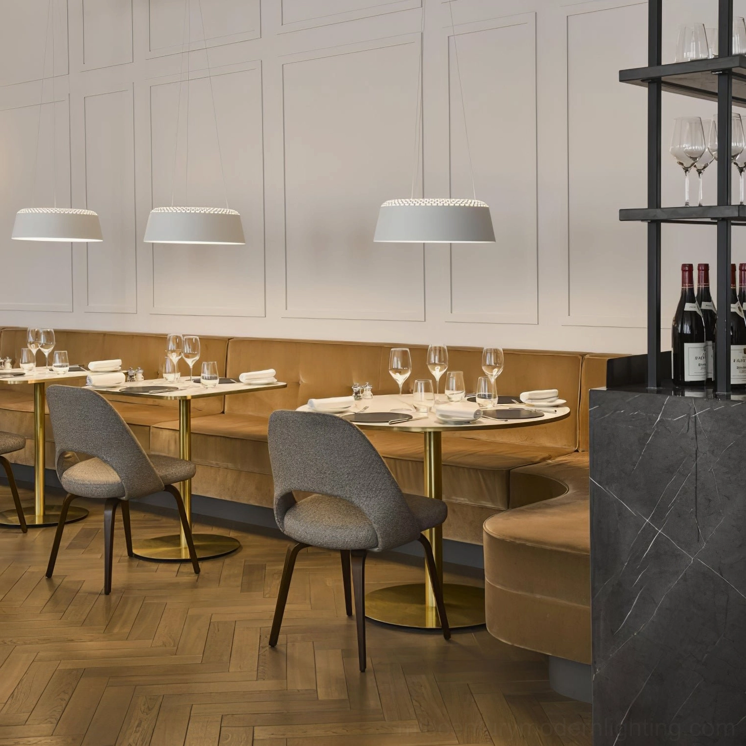 Ring white pendant fixture in formal dining room with herringbone wood flooring and upholstered seating