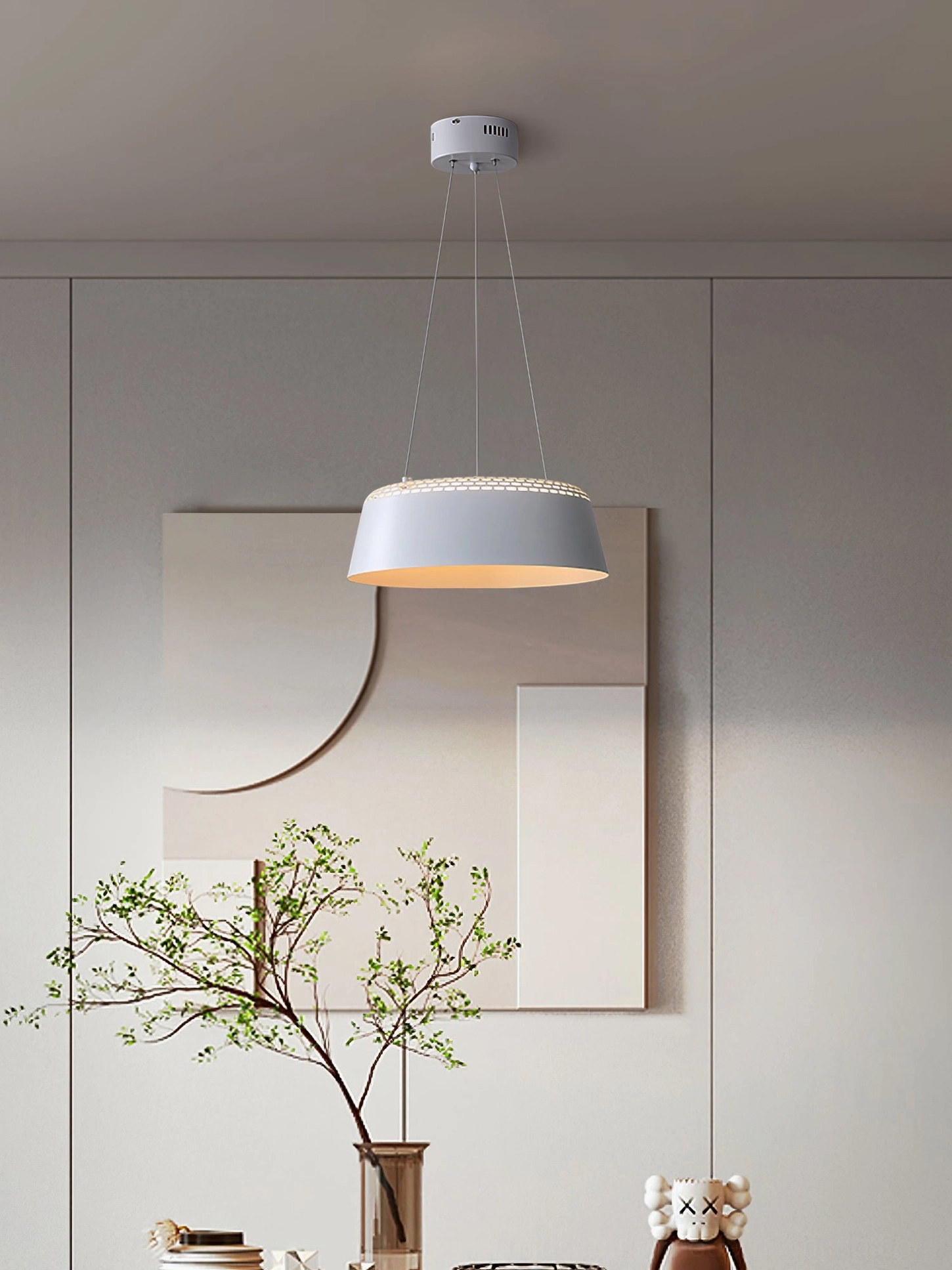 Ring light-toned drum pendant eye-level in minimalist living space with warm glowing light and wall art