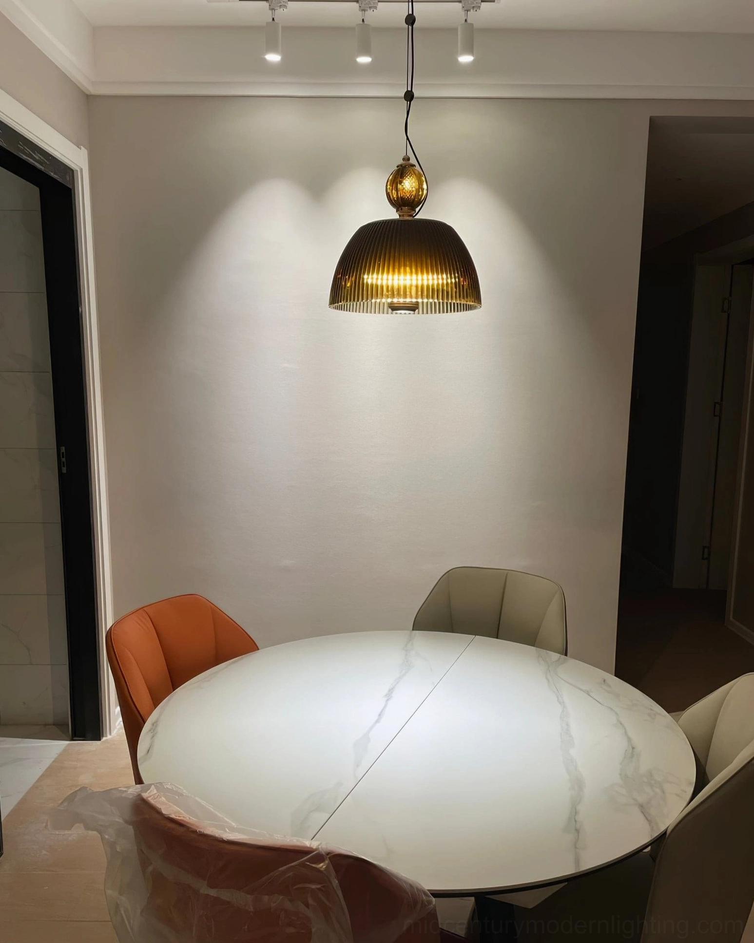 Vintage pendant light fixture with rippled ribbed glass shade reflecting light in contemporary minimalist setting
