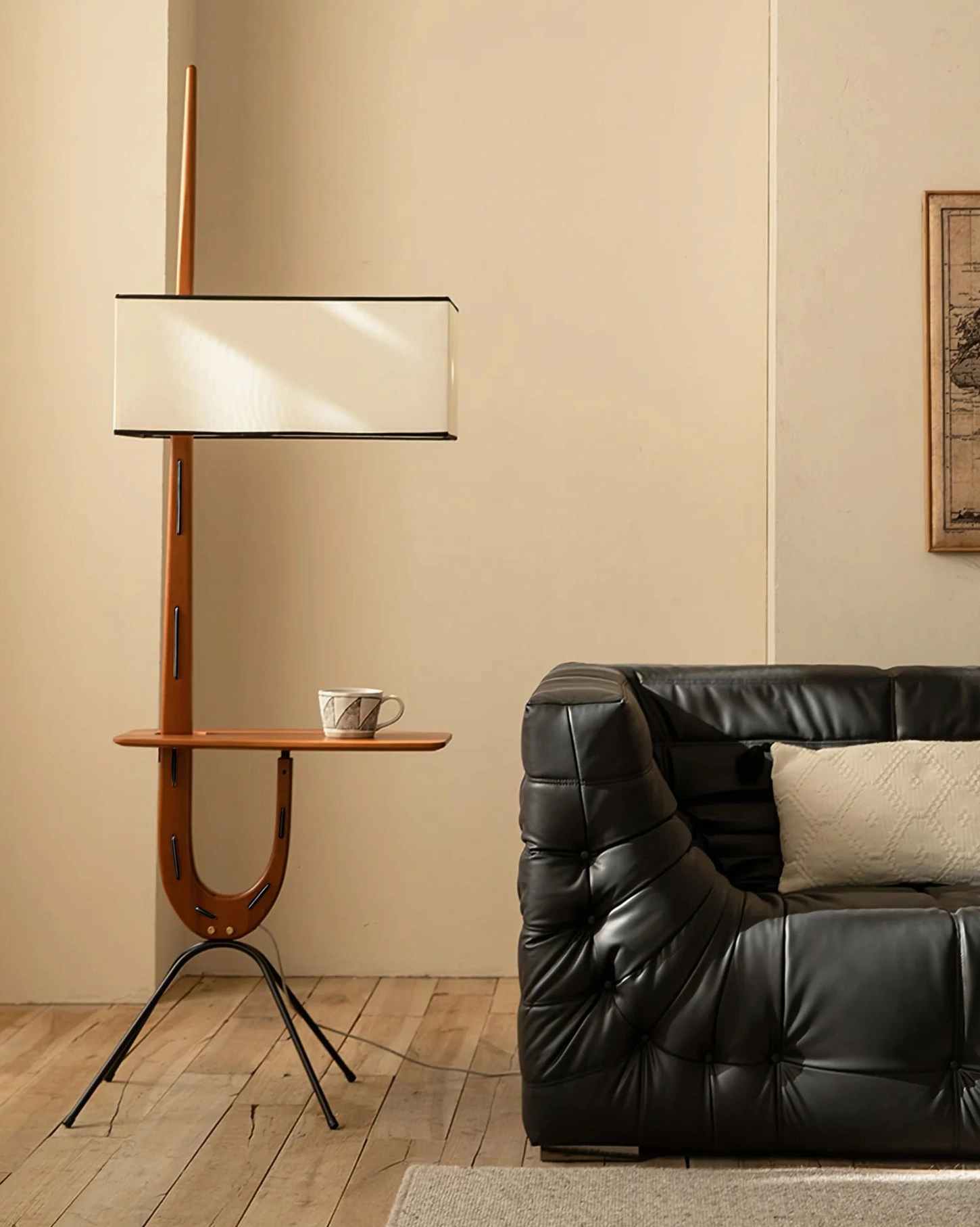 Rispal Floor Lamp positioned beside black leather sofa in modern living room, demonstrating three-quarter angle view and ambient lighting