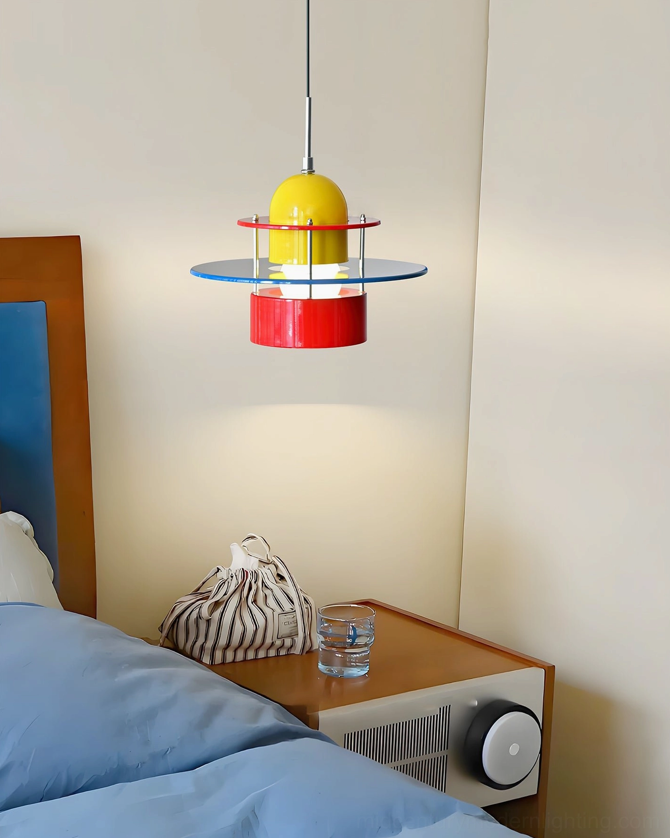 Rolly pendant fixture installed as bedside accent lighting in modern minimalist bedroom space with neutral walls