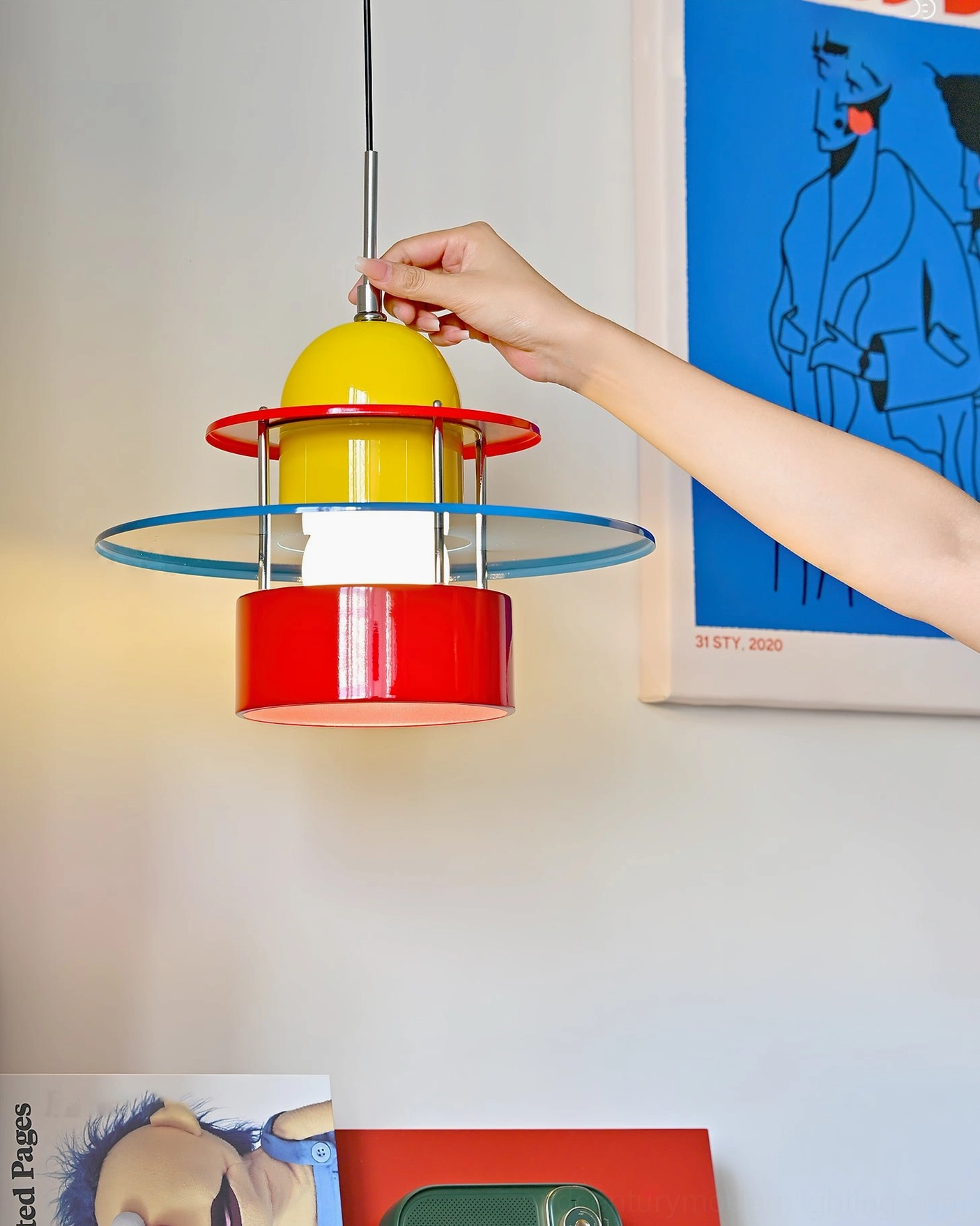 Rolly statement pendant light displayed in home art wall setting with hand for scale showing geometric design aesthetic