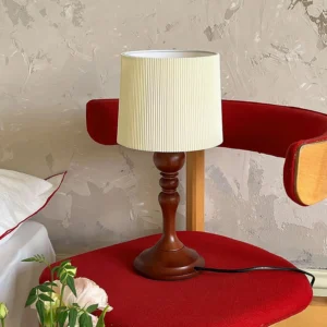 Romeo retro table lamp in bedroom setting with red upholstered chair and warm ambient lighting