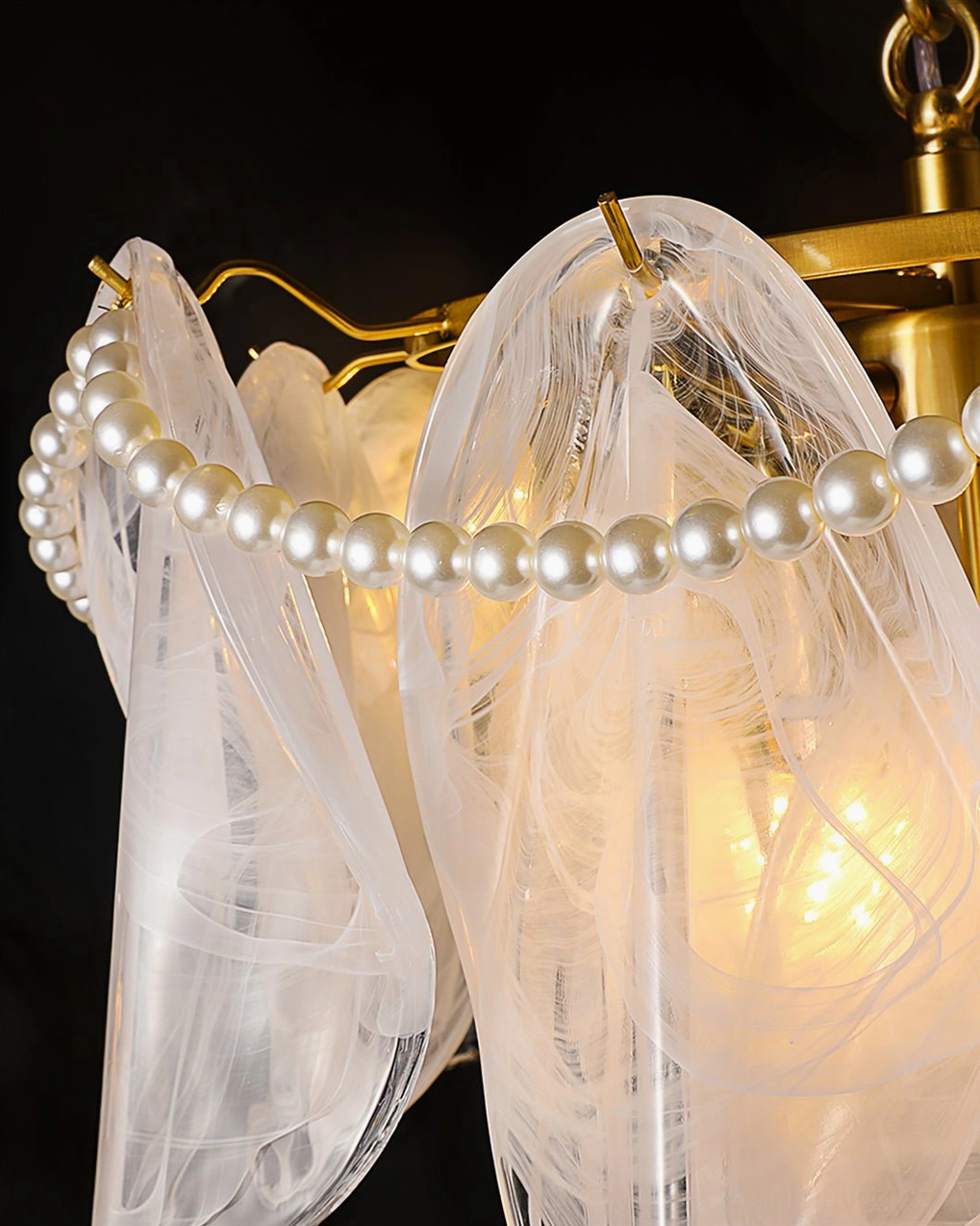 Rondini chandelier trimmed pearl beading edge detail, warm glowing light passing through frosted glass
