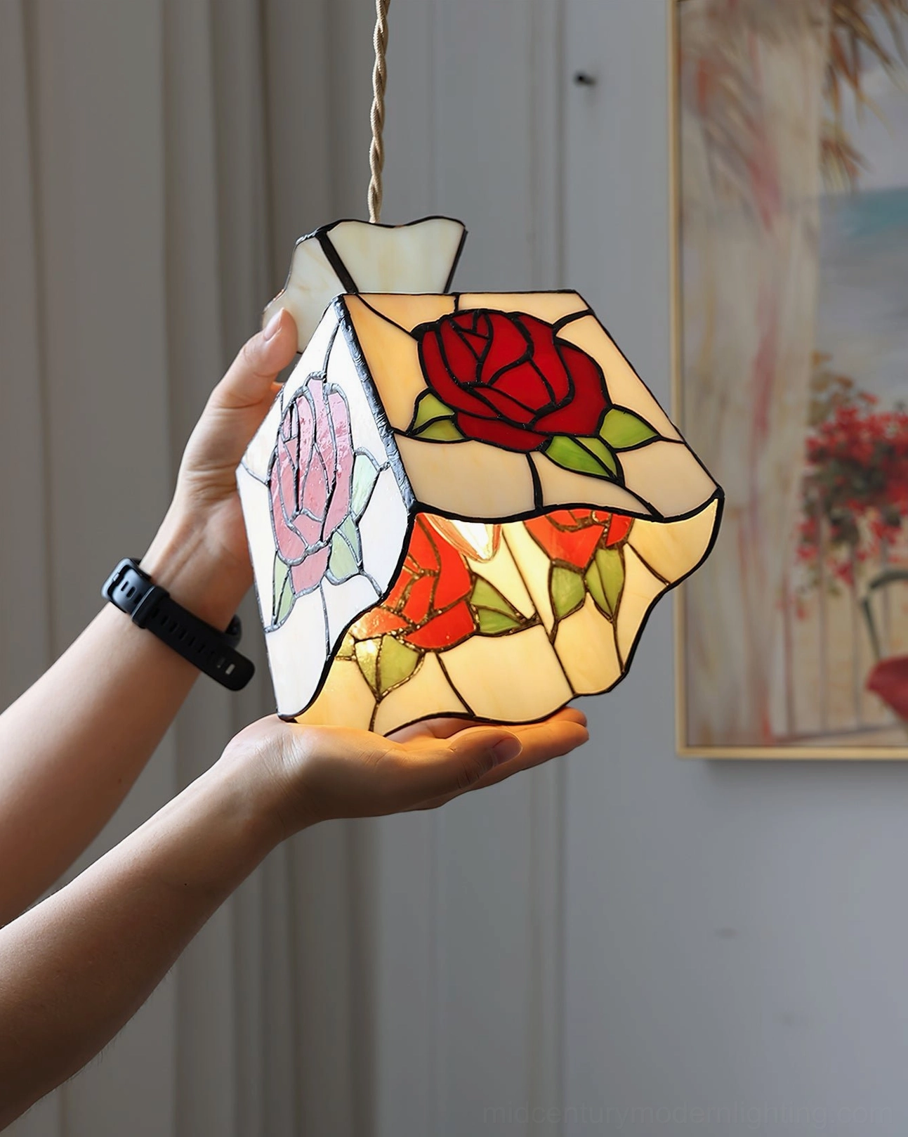 Close-up detail of rose stained glass pendant lamp illuminated from within, showing intricate glass pattern and warm interior glow