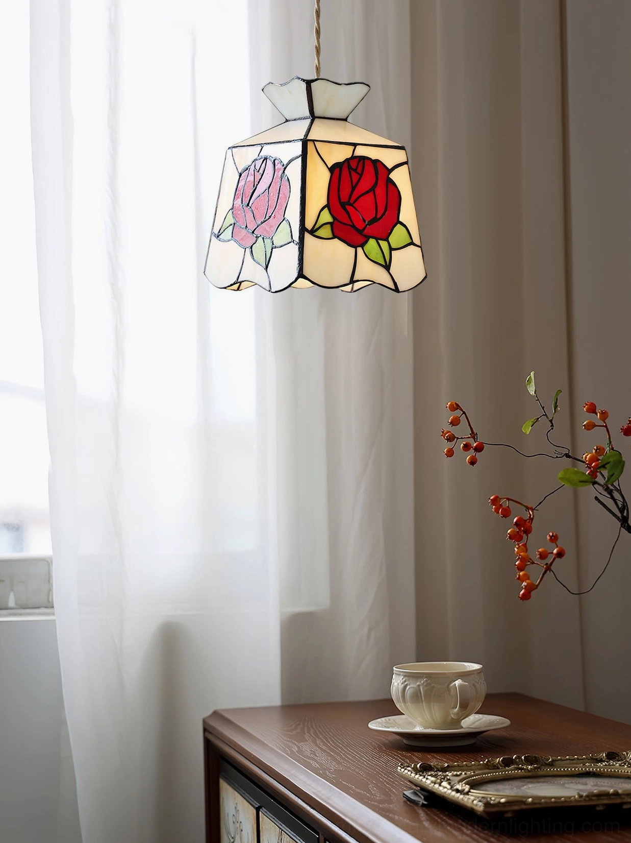 Rose stained glass pendant lamp by window with natural daylight, showing the luminous quality of the hand-crafted glass panels