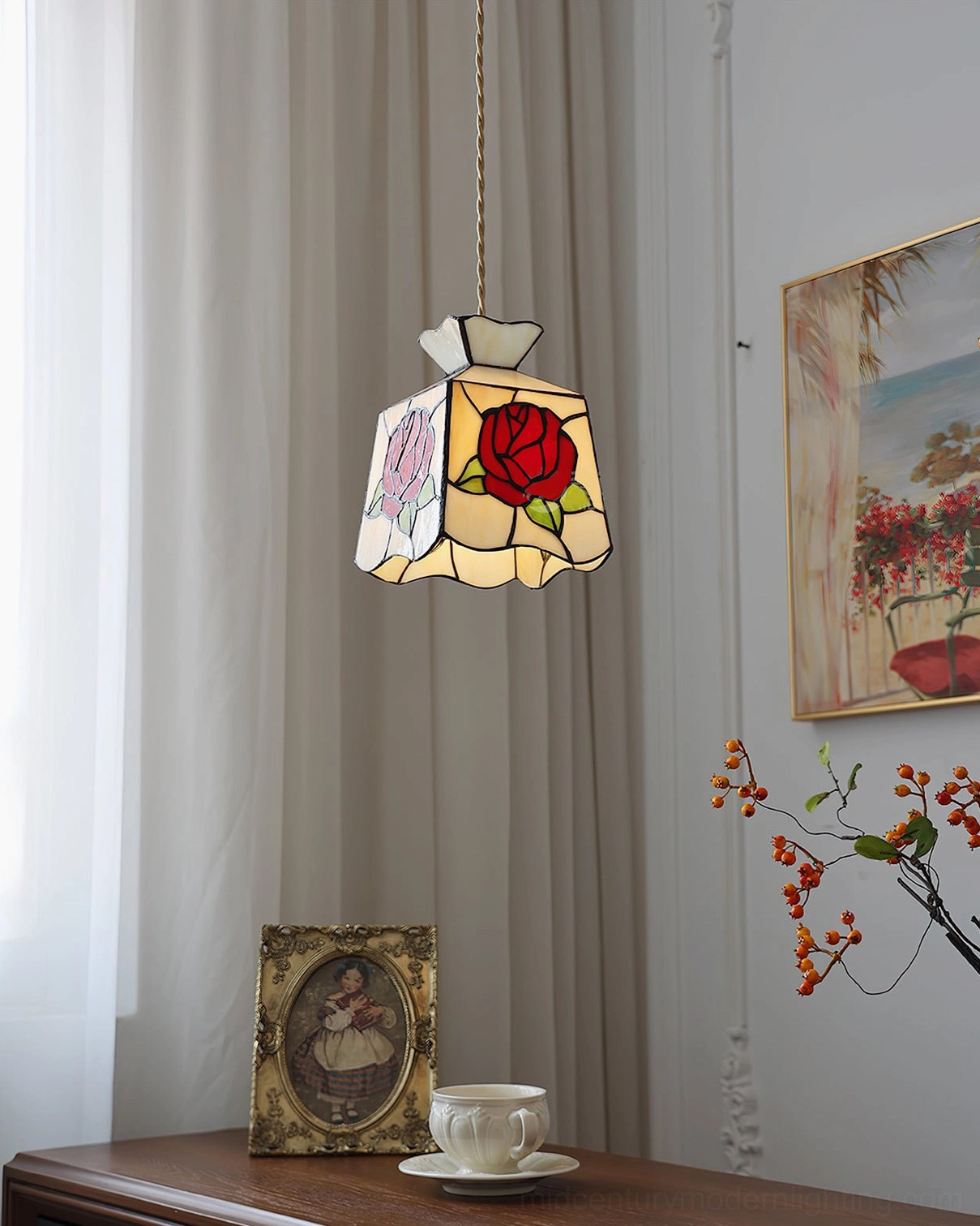 Elegant rose pendant light glowing warmly above decorative table with berry branches and vintage home furnishings