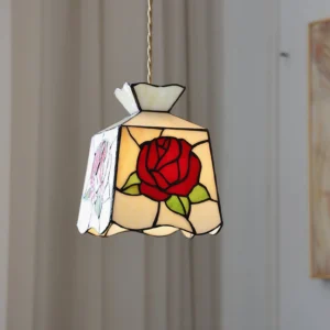Rose pendant light with twisted rope cord hanging from ceiling, side view showcasing the warm glow through botanical stained glass