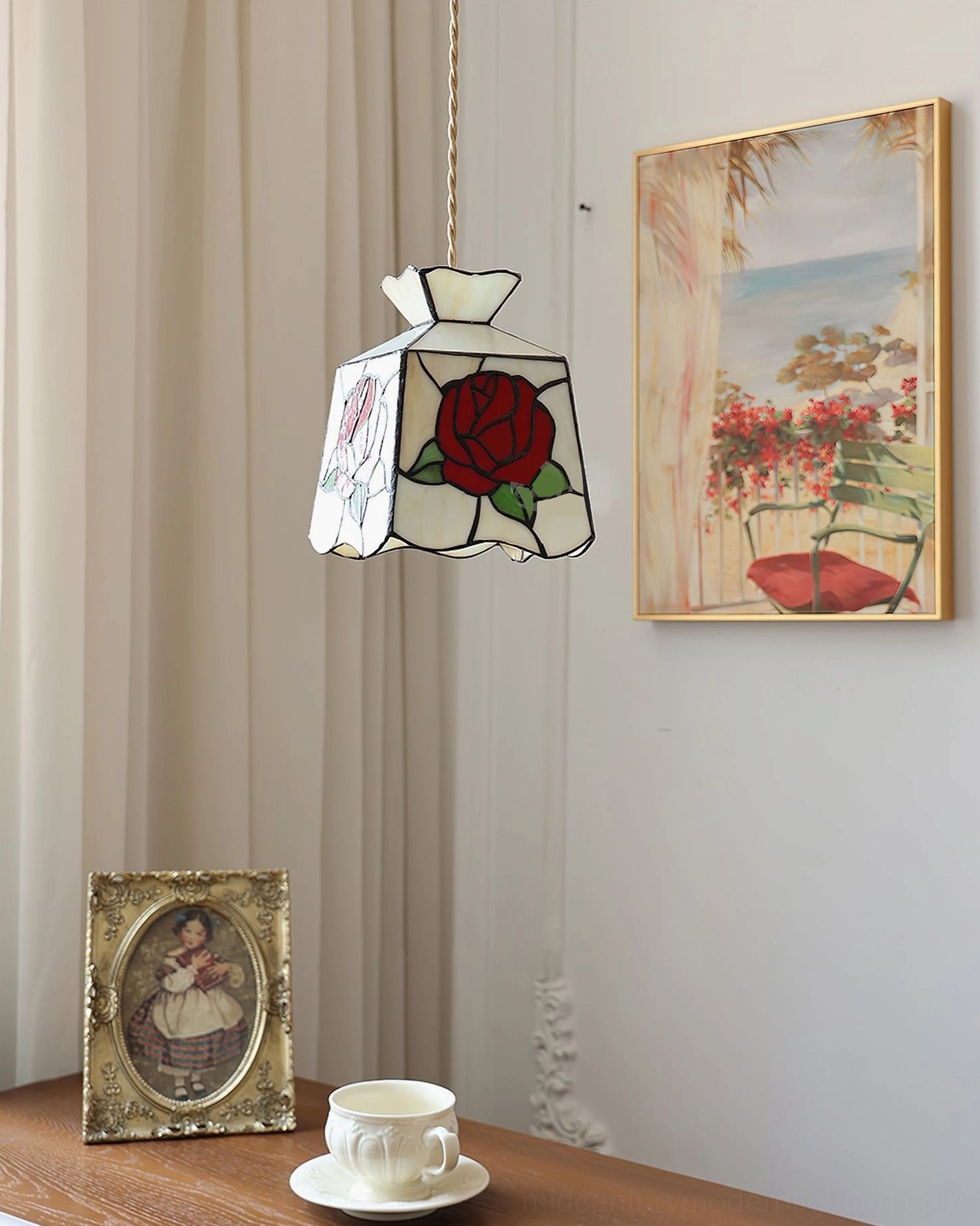 Vintage rose stained glass pendant suspended above wooden table in home setting with framed artwork and wall decor