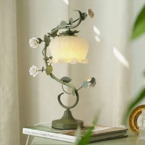 Rose vine table lamp displayed on indoor windowsill with stacked vintage books, French farmhouse style setting