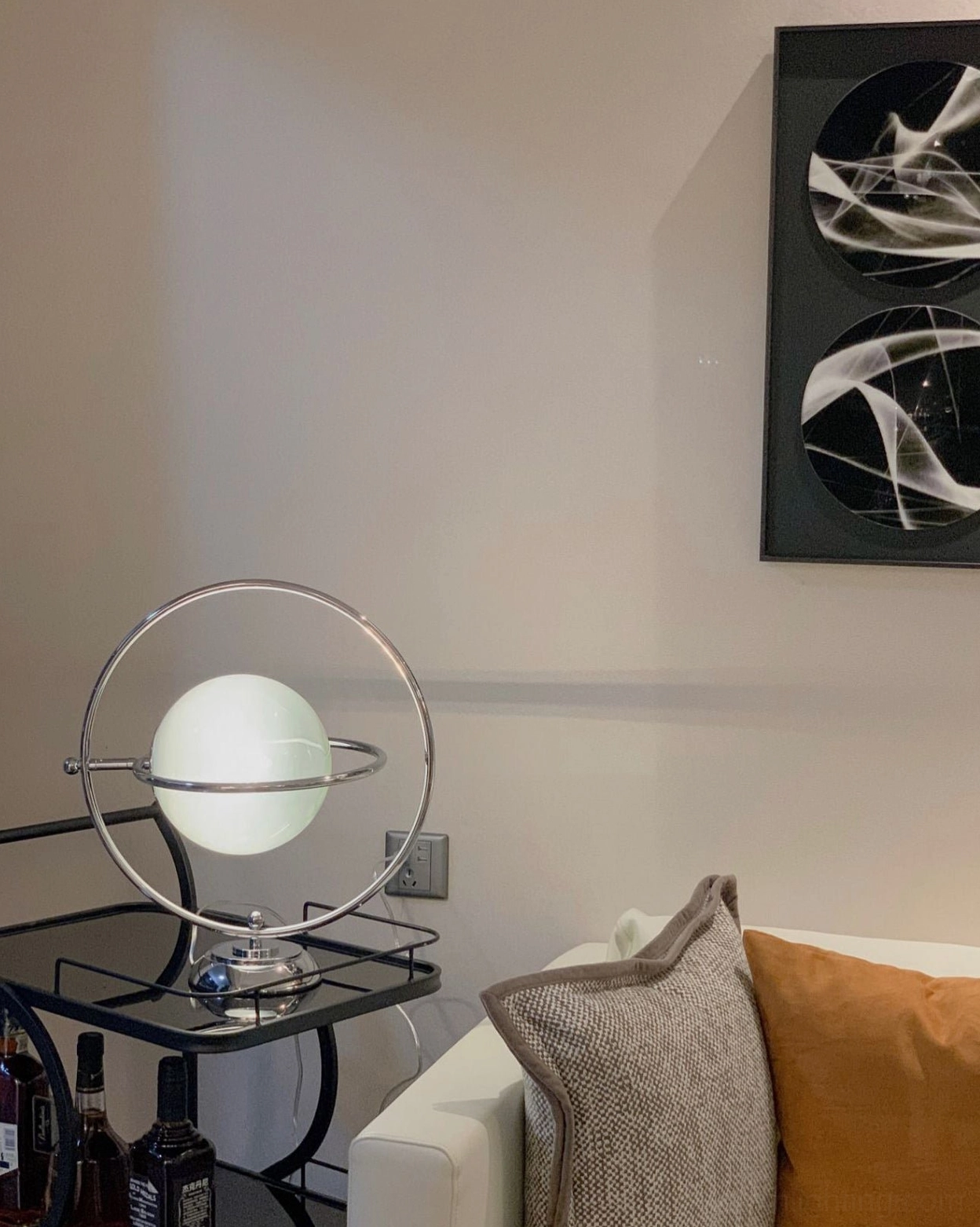 Rotating planet table lamp with polished silver finish and frosted white globe