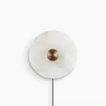 Round alabaster plug-in wall sconce with ribbed bronze center, frontal view on white background