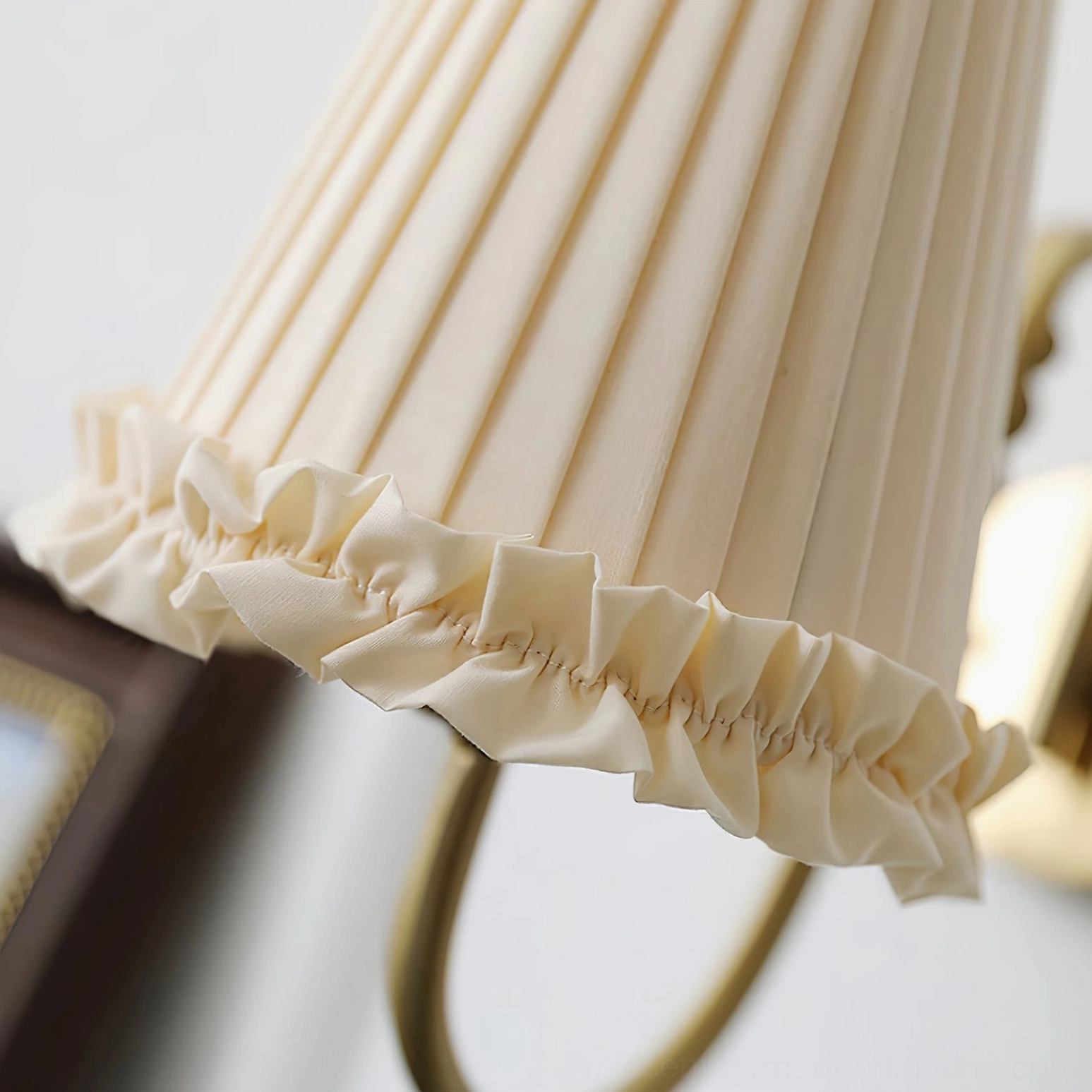 Macro view of beige ruffled frill and vertical pleated fabric texture on wall sconce shade