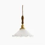 Ruffled glass pendant light with frosted white shade, solid walnut wood and polished brass fixture, overhead flat lay view on white background