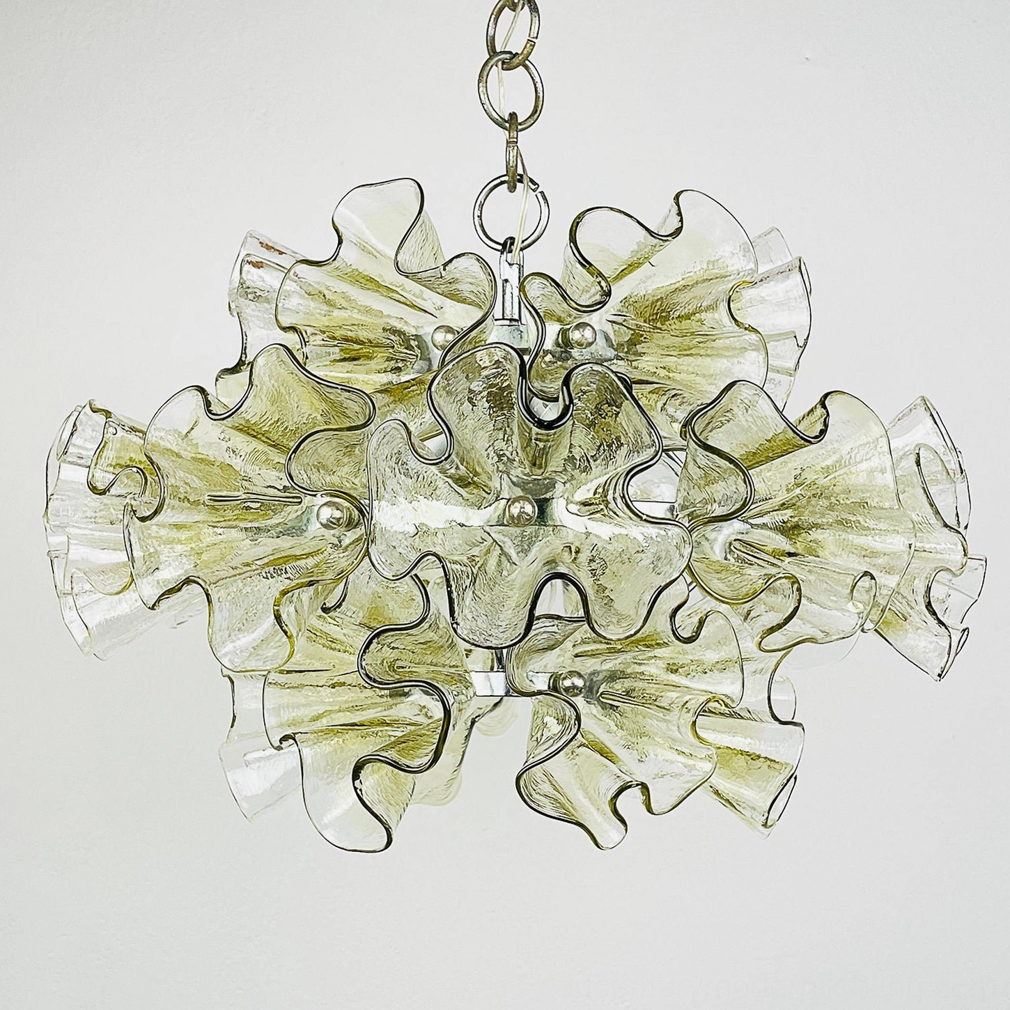 Close-up detail of ruffled glass pendant chandelier showing textured rippled glass petals and chrome hanging chain