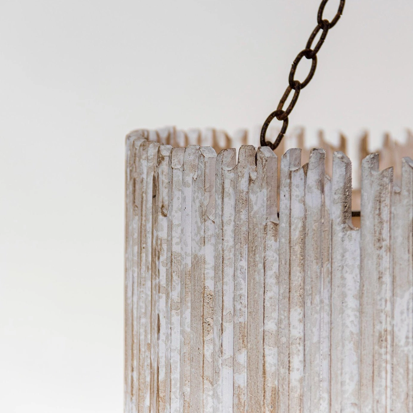 Close-up detail of rustic drum chandelier shade, macro view showing weathered whitewashed wood slats and uneven top edge craftsmanship