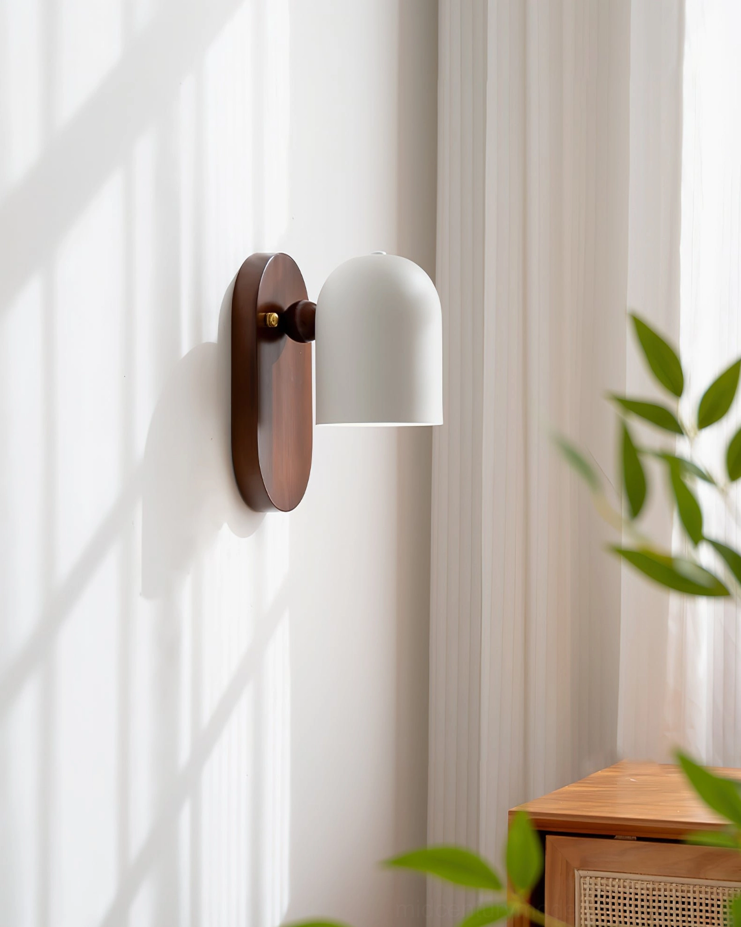 Sable wall lamp glowing with warm light against window shadow pattern for dramatic effect